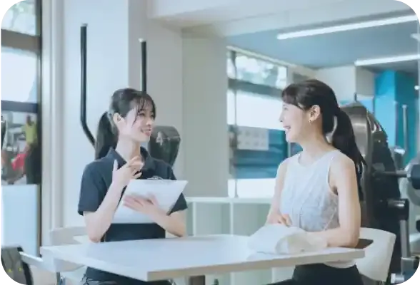 談笑をする女性トレーナーと会員