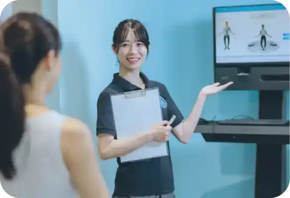 マシンの説明をする女性トレーナー3